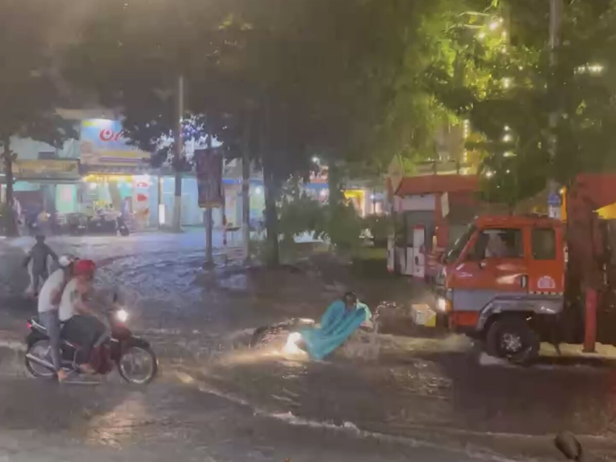 Xe máy đi trên đường bị ngã do nước mưa chảy mạnh.