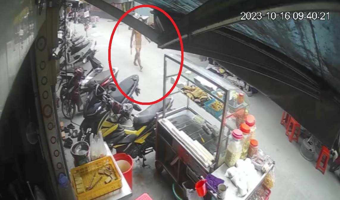 Hình ảnh người đàn ông cầm dao đi trên đường ở đường Nguyễn Thiện Thuật. (Ảnh cắt từ clip)