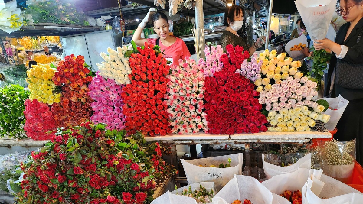 Các cửa hàng trong khu chợ cũng bắt đầu chuẩn bị những mẫu hoa bày ra sạp, cắm vào chậu, hay bó tạo kiểu để phục vụ khách hàng. Chợ hoa Quảng An chỉ trong phút chốc đã như một buổi triển lãm của các loài hoa. Từ các giống hoa quen thuộc như hoa hồng, hoa cúc, hoa lay ơn, hoa đồng tiền, hoa hướng dương,... đến các mẫu hoa nhập khẩu như tuy líp, hoa lan... Ảnh Trịnh Anh