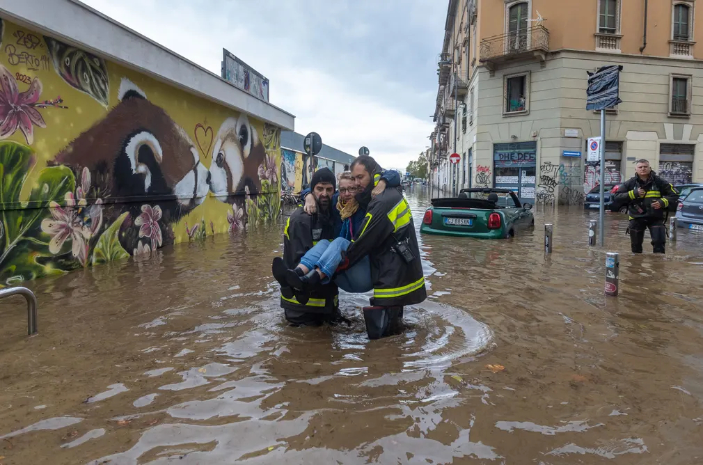 Nhân viên cứu hộ đưa một nữ tài xế bị mắc kẹt trong dòng nước lũ đến khu vực an toàn ở Milan (Italy). (Ảnh: Stefano Porta/LaPresse/Shutterstock)