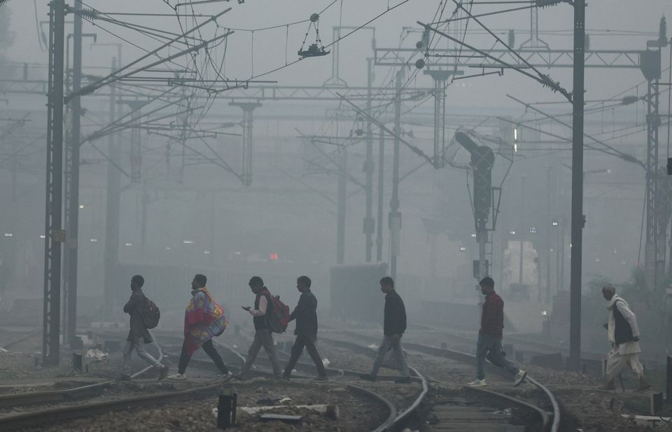 Người dân băng qua đường ray vào sáng nay ở New Delhi (Ấn Độ). (Ảnh: Reuters)