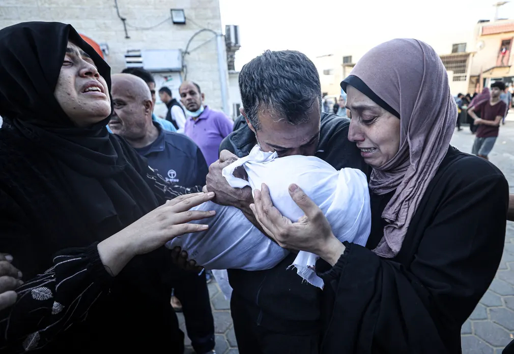 Người thân của một em bé thiệt mạng trong cuộc không kích của Israel đưa thi thể của em từ nhà xác của bệnh viện al - Aqsa đến địa điểm tổ chức tang lễ ở Deir al - Balah (Dải Gaza). (Ảnh: Anadolu Agency/Getty Images)
