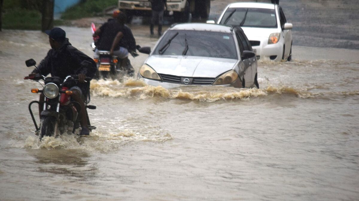 Người lái xe lội qua con đường ngập nước ở thành phố Mombasa (Kenya) sau trận mưa lớn. (Ảnh: AP)