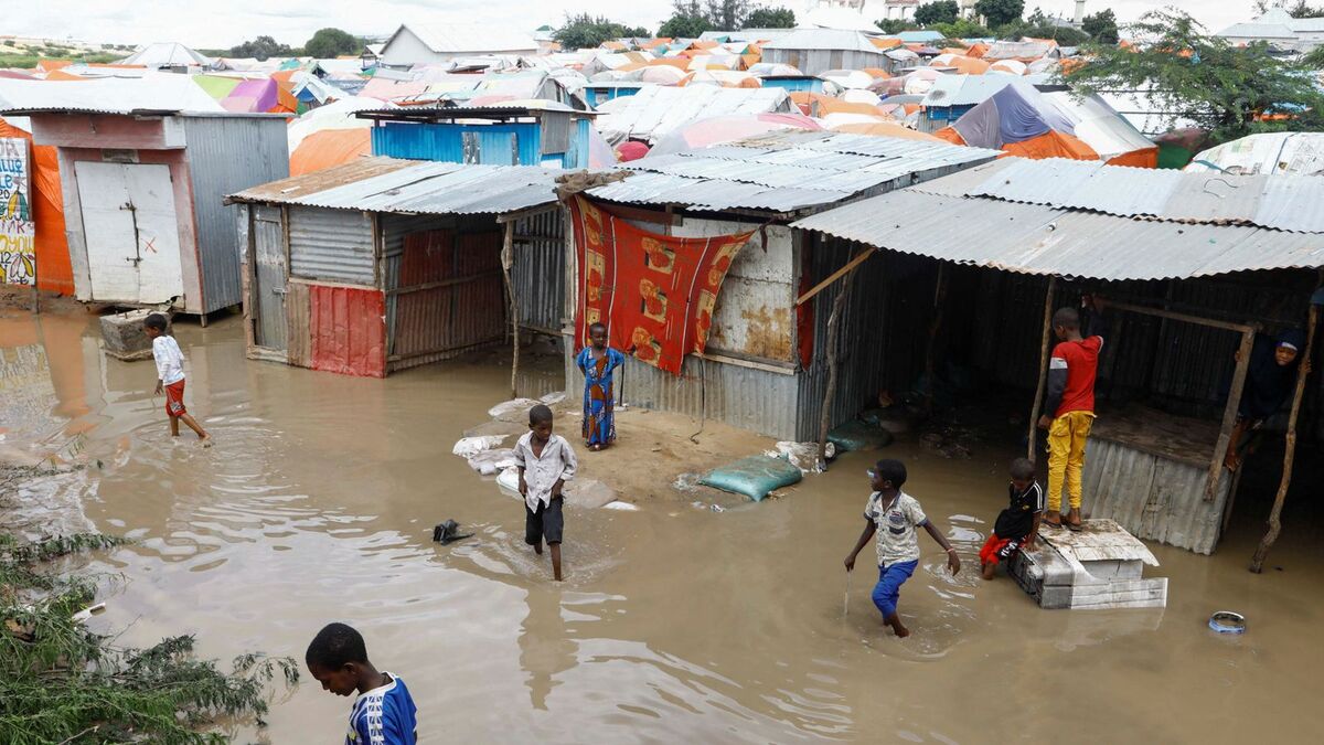 Trẻ em tại Somali lội qua nước lũ bên ngoài nơi trú ẩn tạm bợ.  