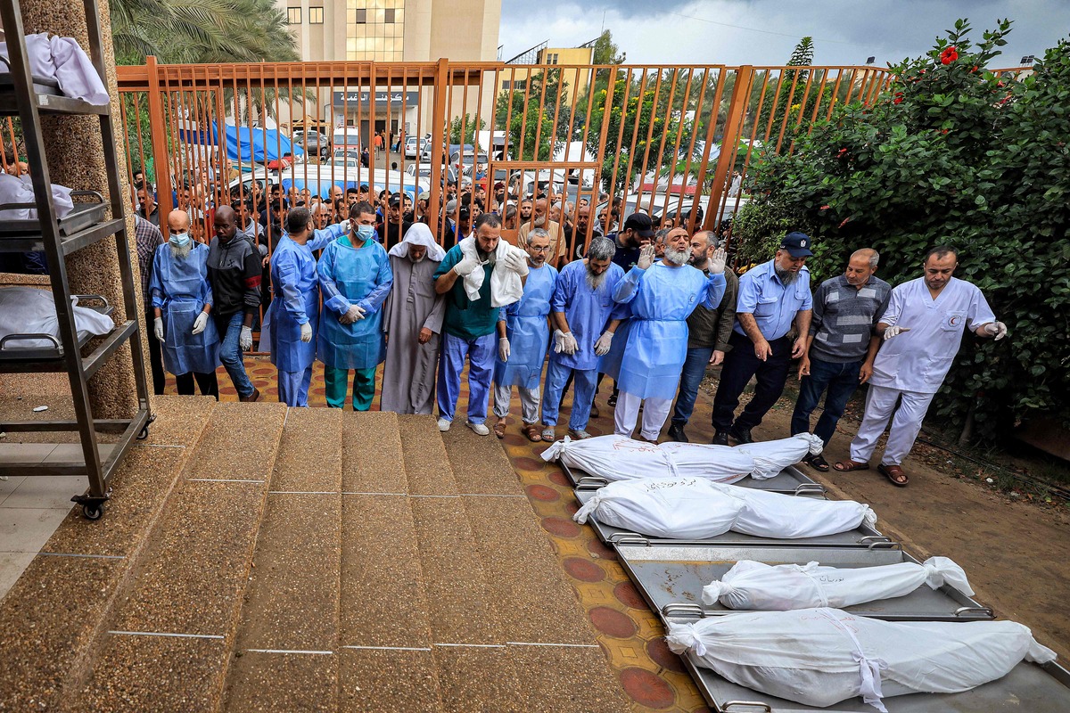 Nhân viên bệnh viện Nasser cầu nguyện cho những người thiệt mạng trong cuộc không kích của Israel hôm 14/11. (Ảnh: AFP)  