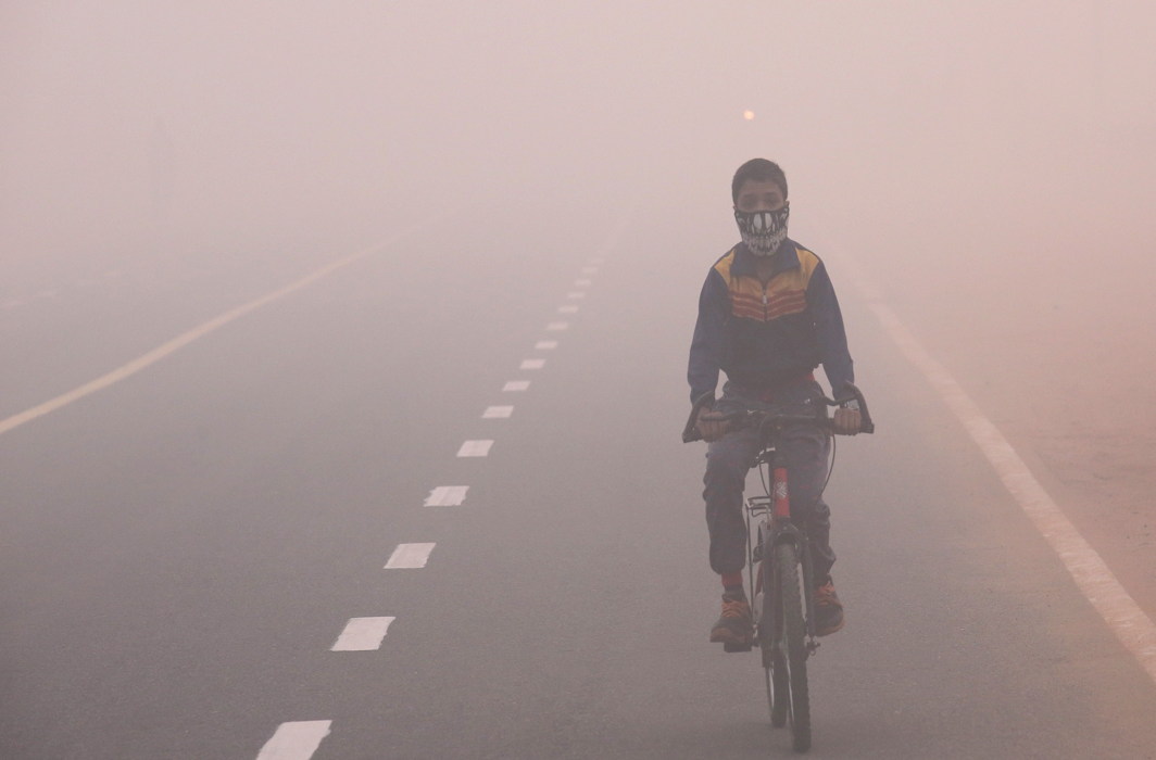 Một người đạp xe trên con đường bao phủ bởi lớp sương dày đặc ở thành phố (Ảnh: APN)