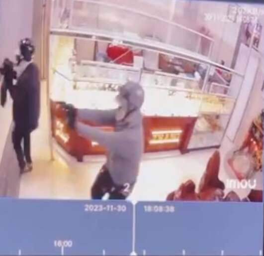 Camera an ninh ghi lại cảnh hai đối tượng dùng súng xông vào tiệm vàng. (Ảnh chụp màn hình)