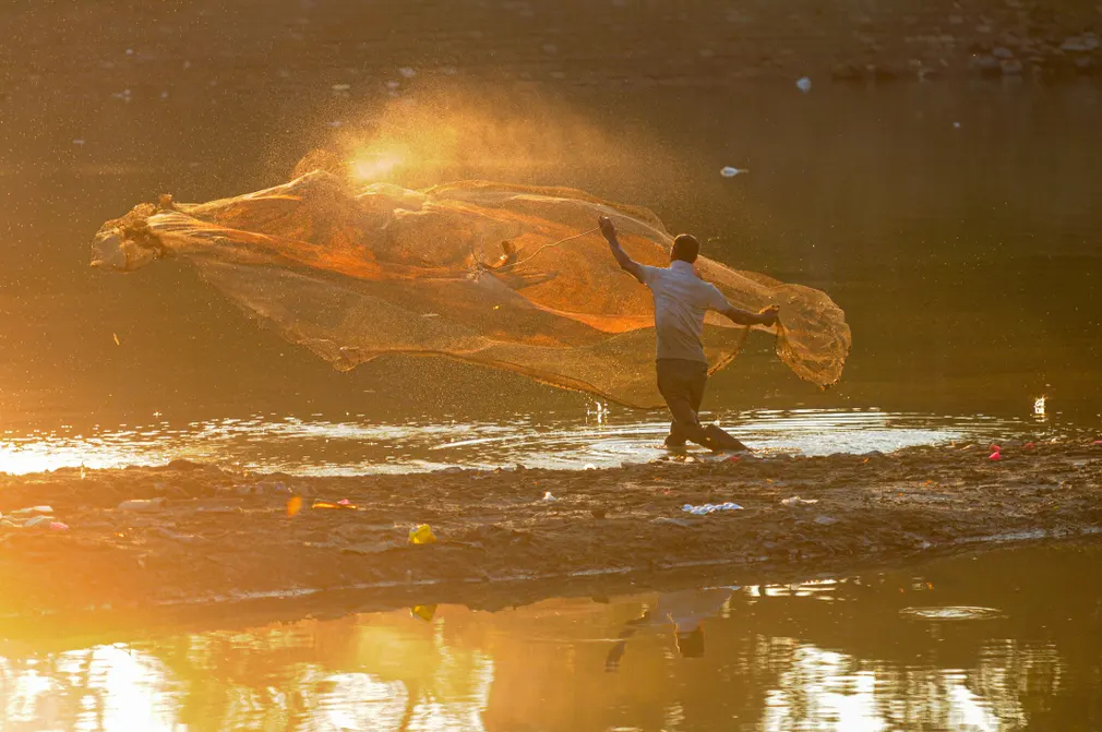 Ngư dân quăng lưới đánh cá bên bờ sông Surma (Sylhet, Bangladesh) bị ô nhiễm. (Ảnh: Md Rafayat Haque Khan/Zuma Press Wire/Shutterstock)