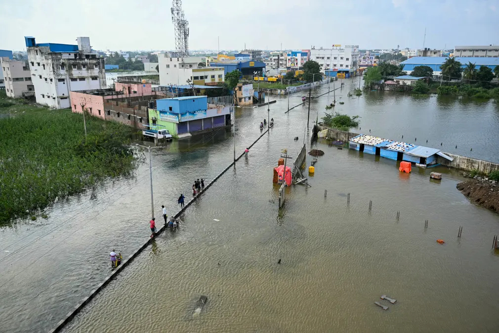 Người dân lội qua con đường ngập nước sau cơn mưa lớn ở Chennai (Ấn Độ). (Ảnh: R Satish Babu/AFP/Getty Images)
