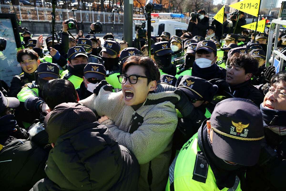 Cảnh sát cố gắng bắt giữ một người đàn ông trong cuộc biểu tình yêu cầu chính phủ hủy bỏ kế hoạch thông qua dự luật thực thi lệnh cấm ăn thịt chó ở Seoul (Hàn Quốc). (Ảnh: REUTERS/Kim Hong Ji)