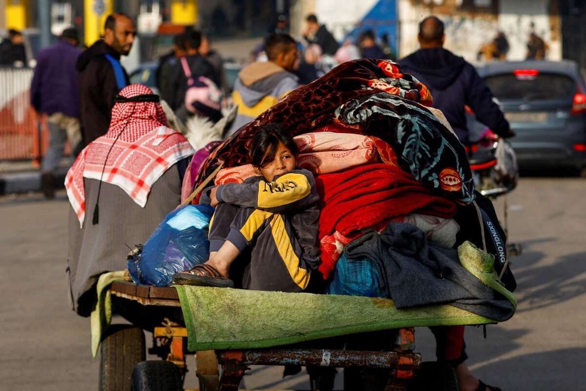 Bé gái ngồi trên xe kéo, cùng gia đình chạy trốn khỏi nhà do các cuộc tấn công của Israel ở thành phố  Khan Younis (Dải Gaza). (Ảnh: REUTERS/Ibraheem Abu Mustafa)