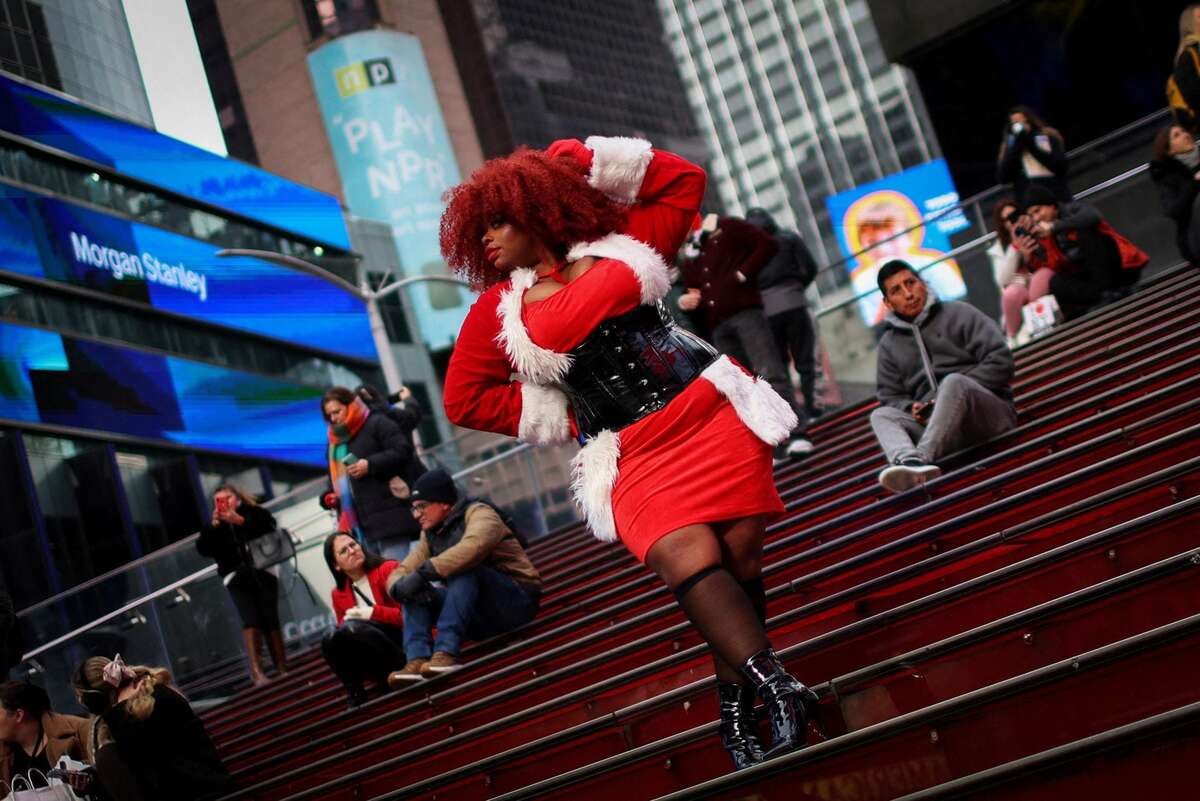 Người phụ nữ mặc trang phục theo chủ đề Giáng sinh, tạo dáng trên bậc thang ở Quảng trường Thời đại (Manhattan, New York, Mỹ). (Ảnh: REUTERS/Mike Segar)