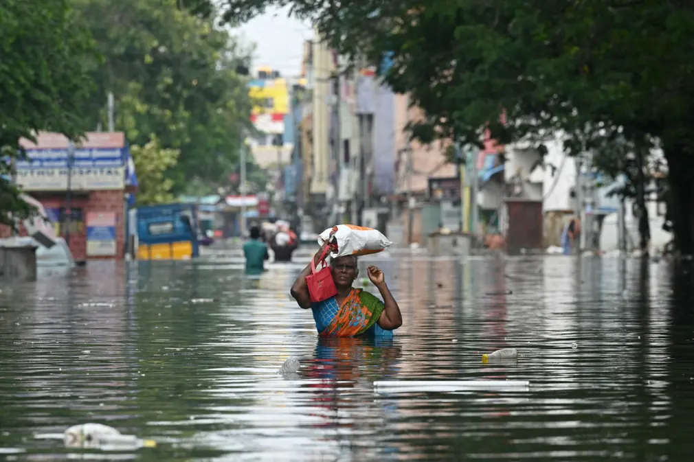 Người phụ nữ lội qua con đường ngập nước sau trận mưa lớn khi cơn bão Michaung đổ bộ vào bờ biển phía Đông Nam Ân Độ. (Ảnh: AFP/Getty)