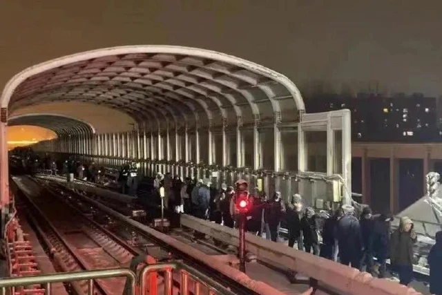 Hành khách đi bộ ra khỏi hiện trường tai nạn tàu điện ngầm Bắc Kinh hôm 14/12. (Ảnh: Weibo)