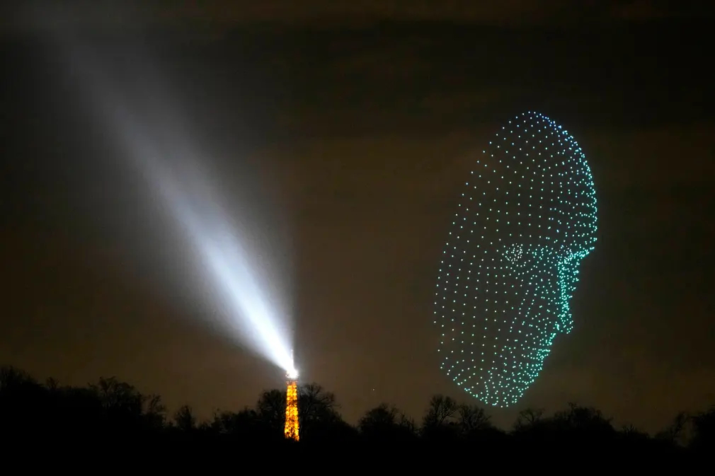 Máy bay không người lái phát sáng bay lượn gần tháp Eiffel (Paris, Pháp). (Ảnh: Christophe Ena/AP)