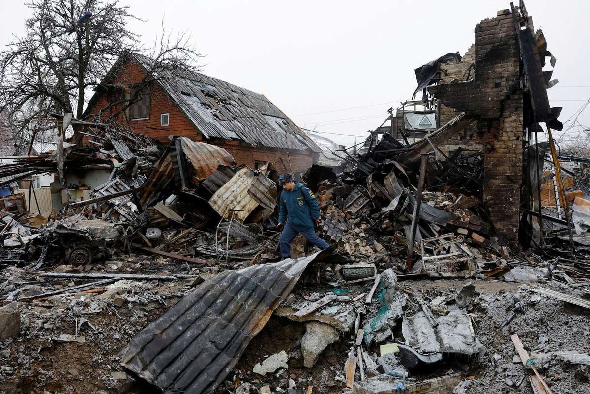 Thành viên của Bộ tình trạng khẩn cấp địa phương kiểm tra tàn tích của một ngôi nhà bị phá hủy ở Yasynuvata (Ukraine). (Ảnh: REUTERS/Alexander Ermochenko)