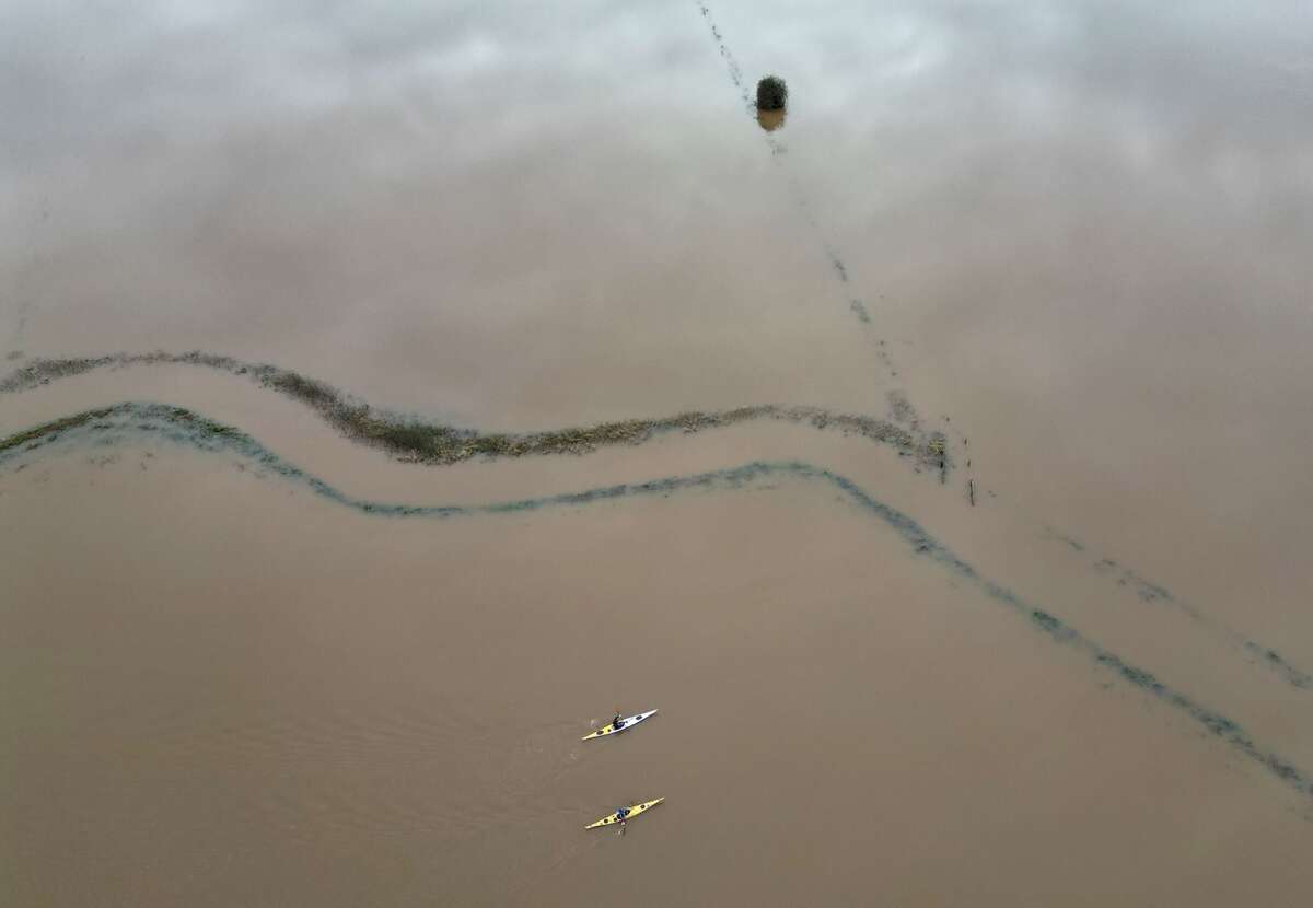 Người dân chèo thuyền qua những cánh đồng ngập nước gần Langport (Somerset, Vương quốc Anh). (Ảnh: REUTERS/Toby Melville)