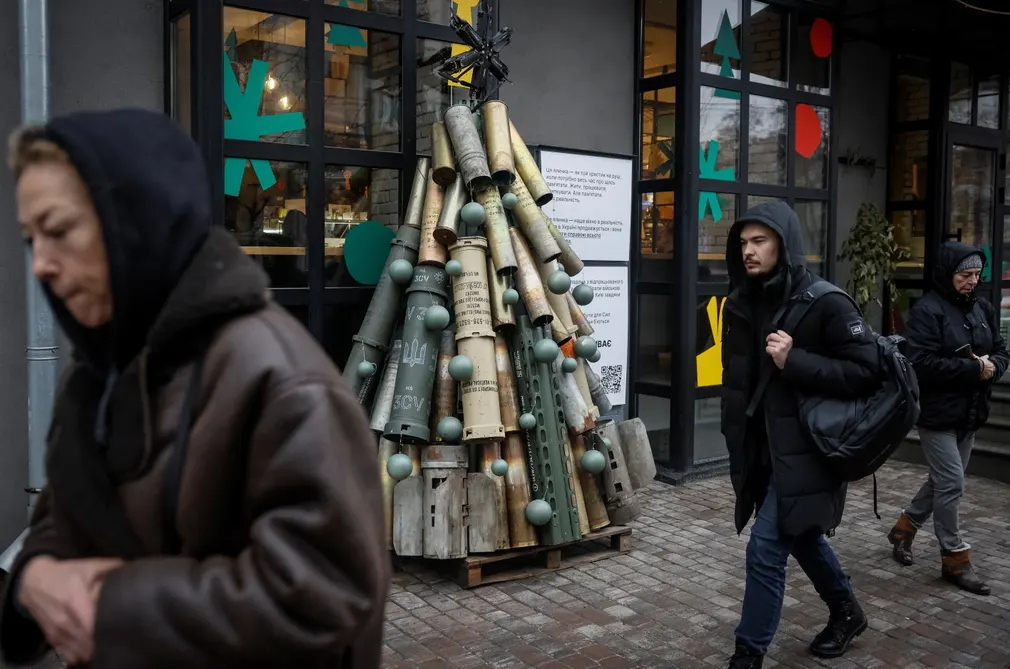 Người dân đi bộ ngang qua cây thông Noel được làm từ đạn pháo đã qua sử dụng và các bộ phận của tên lửa ở Kiev (Ukraine). (Ảnh: Gleb Garanich/Reuters)
Ảnh: Gleb Garanich/Reuters