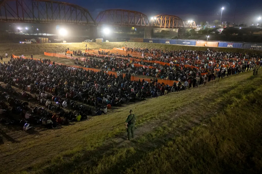 Sĩ quan tuần tra biên giới theo dõi hơn 2.000 người di cư tại một trung tâm xử lý hiện trường ở Texas (Mỹ). (Ảnh: John Moore/Getty Images)