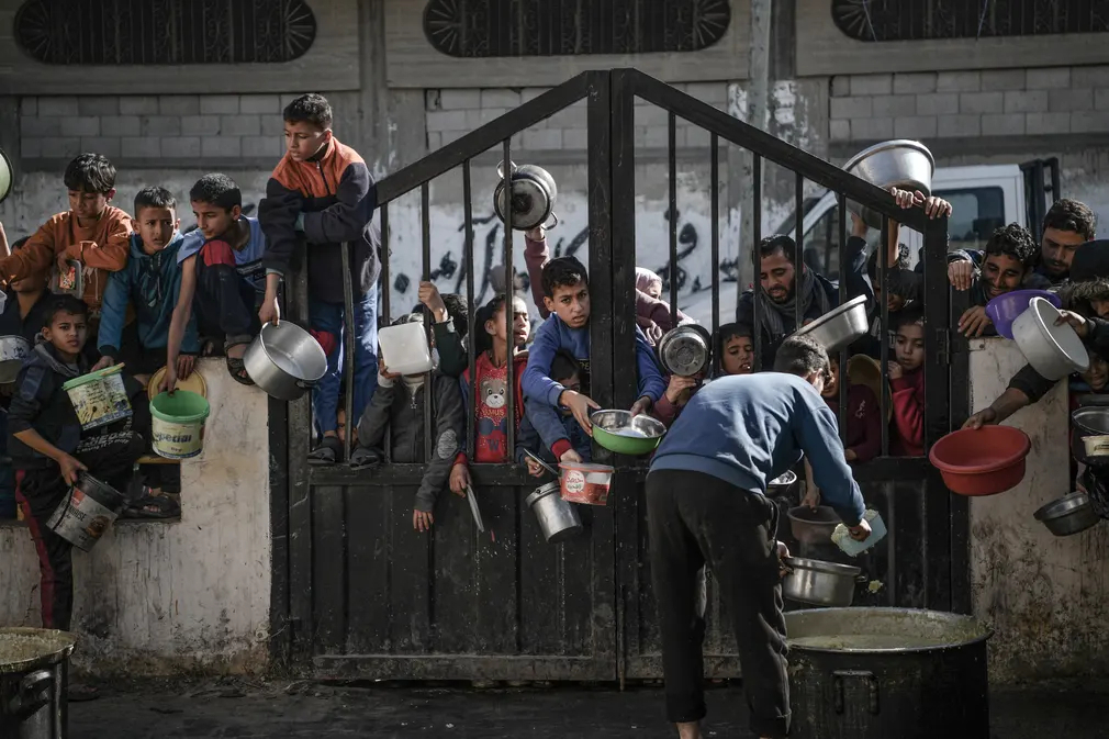 Người dân Palestine chờ đợi được phân phát lương thực và viện trợ nhân đạo khi các cuộc không kích của Israel vẫn tiếp tục diễn ra tại Dải Gaza. (Ảnh: Abed Zagout/Anadolu/Getty Images)
