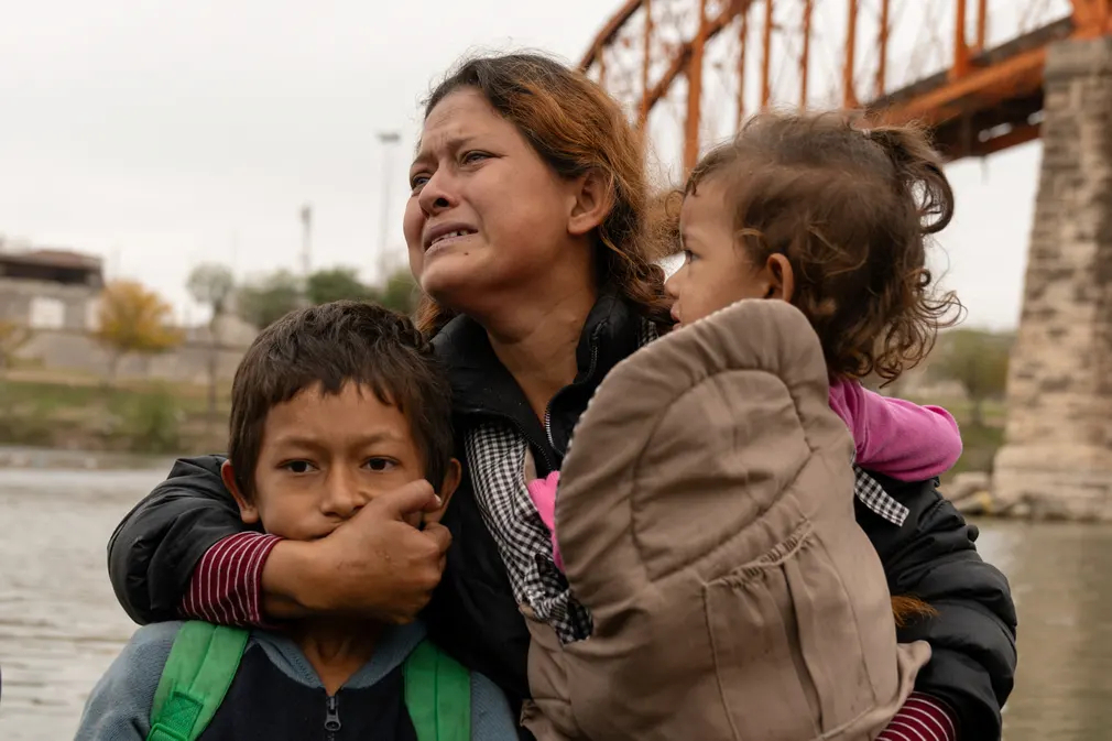 Chị Irma Yolani Cruz ôm các con khóc sau khi băng qua sông Rio Grande từ Mexico để đến Texas (Mỹ). (Ảnh: Cheney Orr/Reuters)
