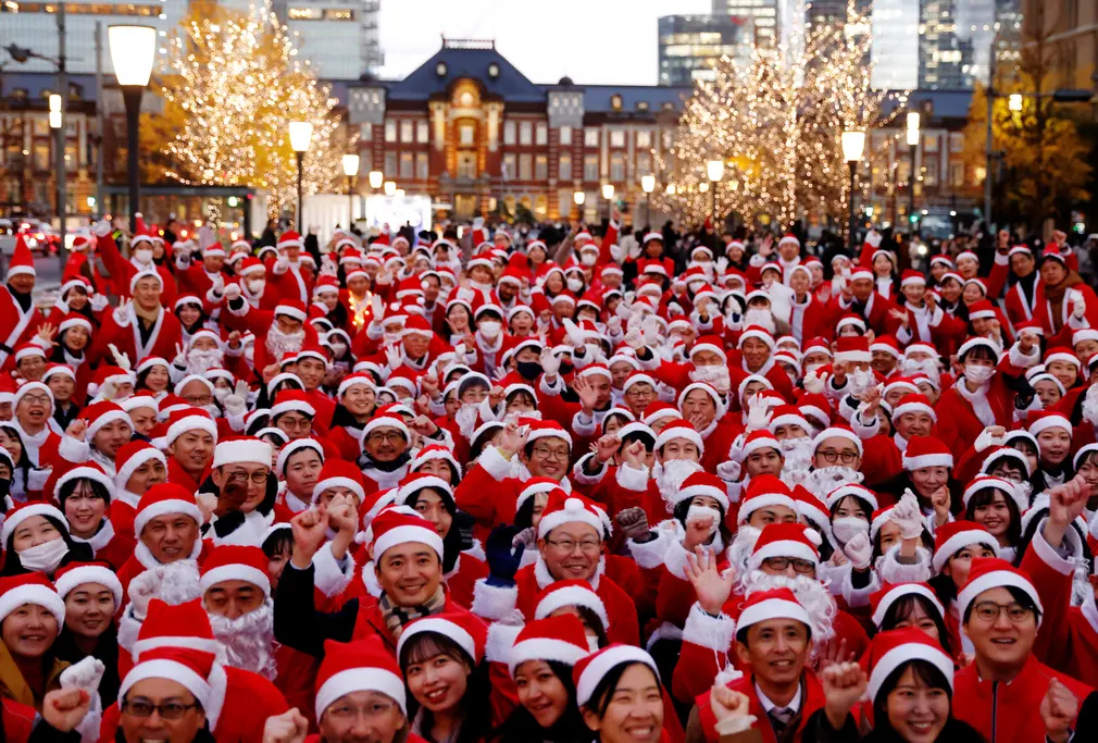 Người dân mặc trang phục ông già Noel, tạo dáng chụp ảnh trước khi phát quà và dọn dẹp đường phố ở Tokyo (Nhật Bản). (Ảnh: Kim Kyung - Hoon/Reuters)
