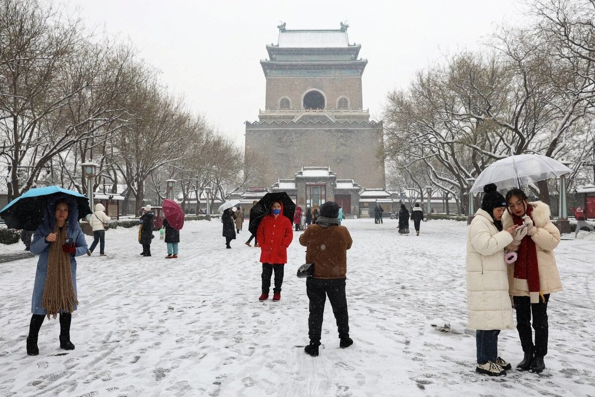 Du khách đến thăm Tháp Chuông trong khi tuyết rơi dày ở Bắc Kinh (Trung Quốc).  