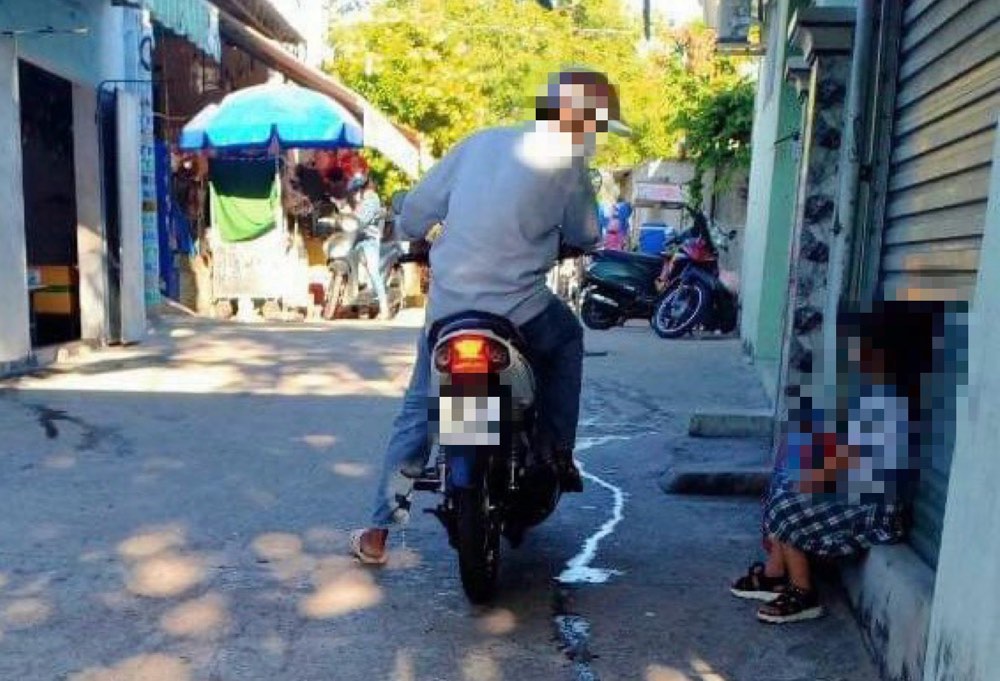 Hình ảnh người lạ đi xe máy tiếp cận em học sinh trước cổng trường tiểu học Mũi Né 2 bị bảo vệ cảnh giác chụp lại. (Ảnh: N.D.C.C.)  