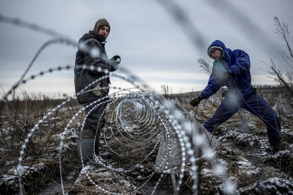 Công nhân lắp đặt dây thép gai ở vùng Kharkov (Ukraine). (Ảnh: Viacheslav Ratynskyi/Reuters)