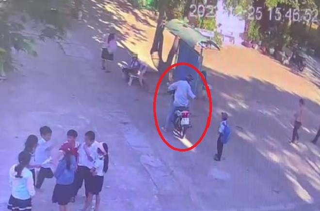 Hình ảnh người đàn ông lạ mặt đi xe máy lui tới trong sân trường để tiếp cận học sinh. (Ảnh cắt từ camera)  