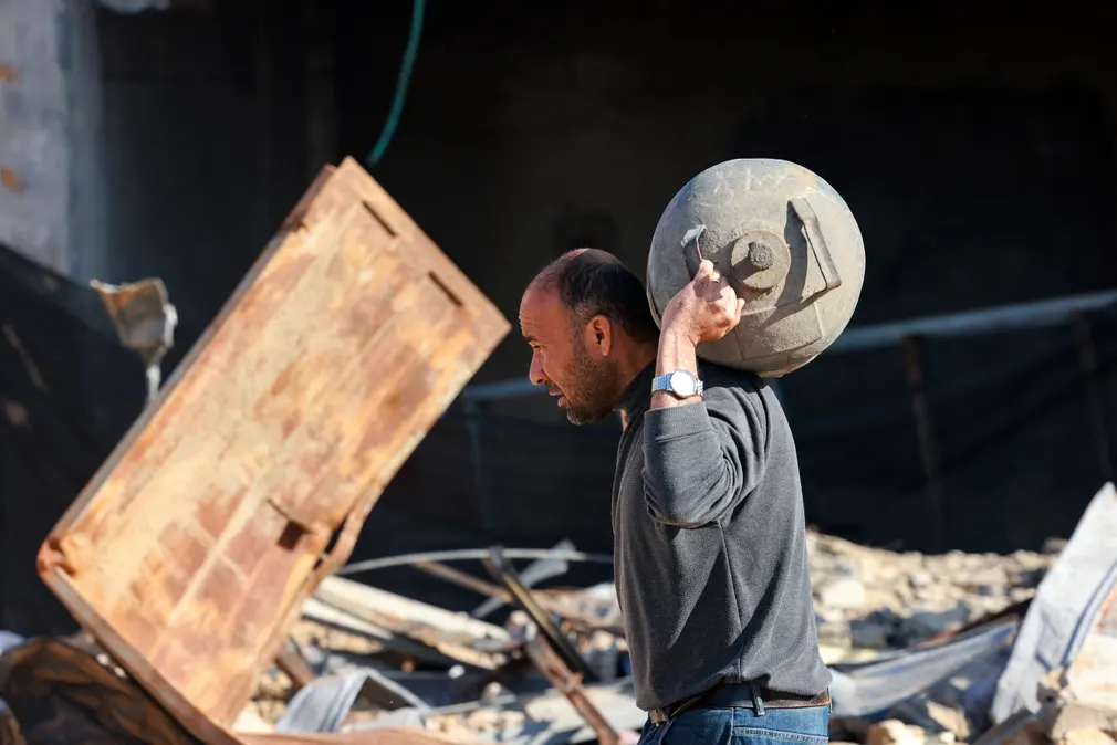 Người đàn ông đi ngang qua tòa nhà bị phá hủy trong vụ đánh bom của Israel ở Rafah (Gaza). (Ảnh: AFP/Getty Images)