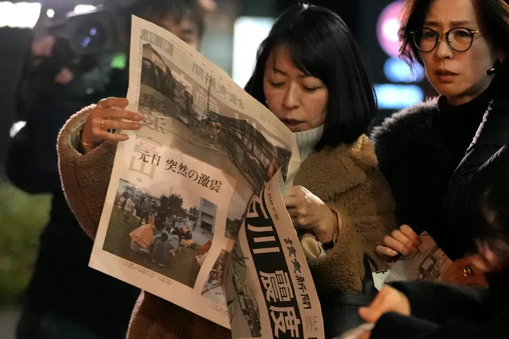 Người dân đọc bản tin trên tờ báo Yomiuri Shimbun về trận động đất mạnh 7,6 độ richter ở thành phố Wajima (tỉnh Ishikawa, Nhật Bản). (Ảnh: Ảnh: Shuji Kajiyama/AP)