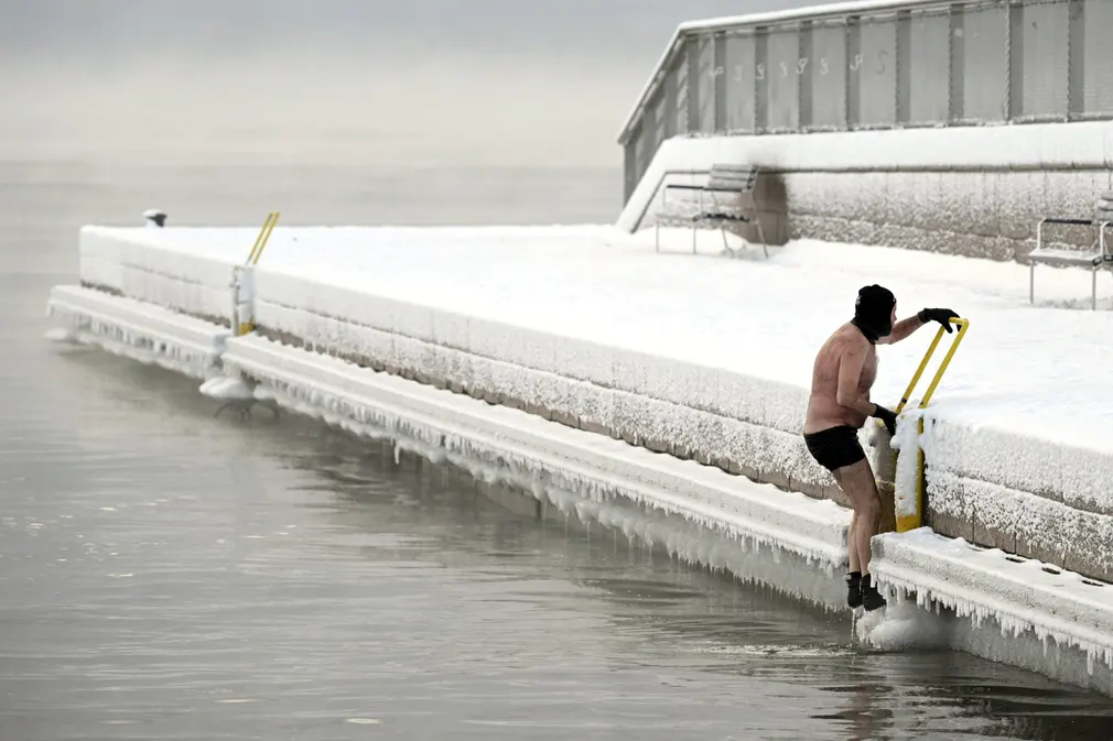 Người đàn ông trèo lên thuyền sau khi bơi trong dòng nước băng giá ở Helsinki (Phần Lan). (Ảnh: Vesa Moilanen/Lehtikuva/AFP/Getty Images)