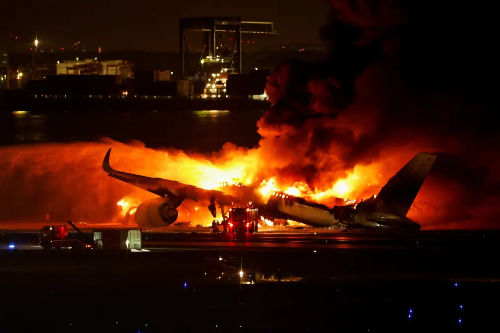 Lính cứu hỏa dập lửa sau khi chiếc máy bay A350 của Japan Airlines bốc cháy tại Sân bay Haneda (Tokyo, Nhật Bản). (Ảnh: Issei Kato/Reuters)