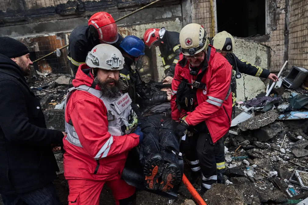 Nhân viên cứu hộ giúp đỡ người đàn ông bị thương tại một tòa nhà bị phá hủy ở Kiev (Ukraine). (Ảnh: Libkos/Getty)