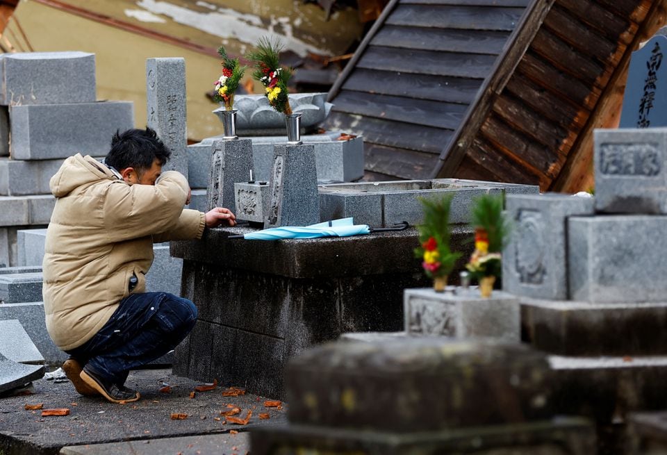 Một người đàn ông bị mất nhà trong trận động đất đến thăm nghĩa trang của cha mẹ mình, nơi bị rung chuyển bởi trận động đất, ở Wajima, Nhật Bản. (Ảnh: Reuters)