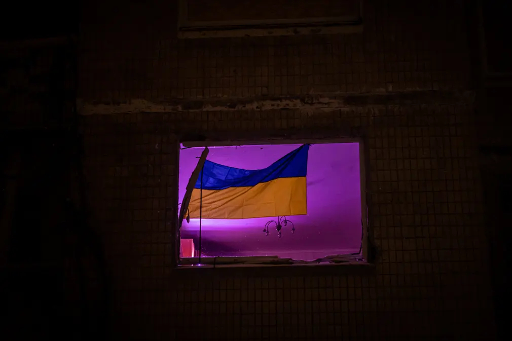 Quốc kì được treo trên cửa sổ của một tòa nhà chung cư bị hư hại ở Kiev (Ukraine). (Ảnh: Global Images Ukraine/Getty Images)