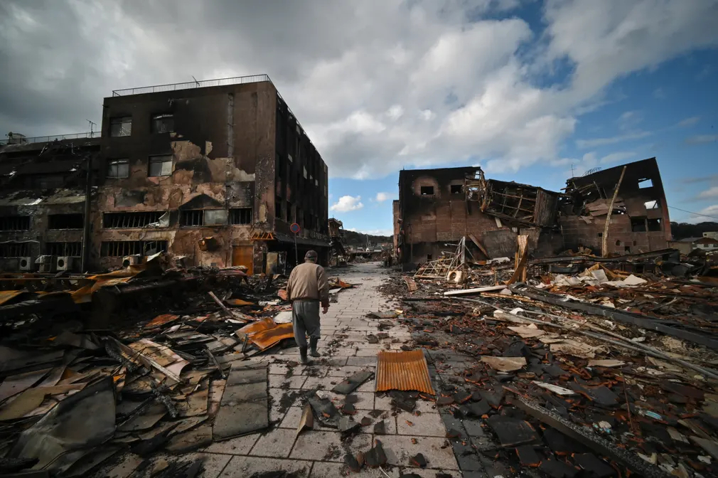 Người đàn ông đi qua đống đổ nát của khu mua sắm ở thành phố Wajima (tỉnh Ishikawa, Nhật Bản) sau trận động đất kinh hoàng. (Ảnh: AFP/Getty Images)