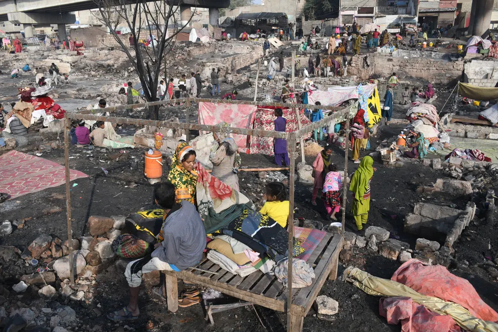 Người dân thu dọn đồ đạc từ đống đổ nát sau khi hỏa hoạn bùng phát ở khu ổ chuột Teen Hatti (Karachi, Pakistan). (Ảnh: Anadolu/Getty Images)