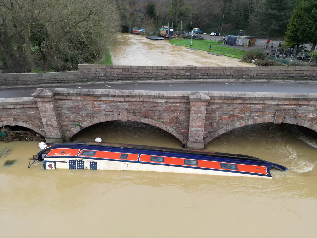 Chiếc thuyền nằm cạnh cây cầu đường bộ bắc qua sông Soar (Leicestershire, Vương quốc Anh) sau khi bị lũ cuốn trôi trong cơn bão Henk.
(Ảnh: Christopher Furlong/Getty Images)
