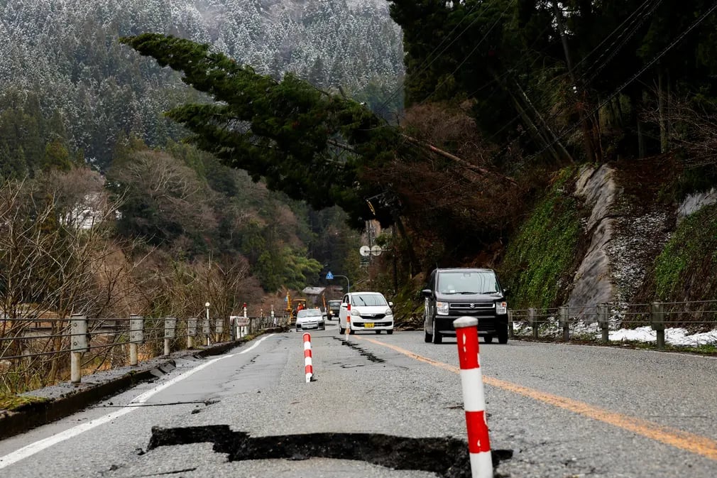 Các phương tiện di chuyển qua con đường bị hư hại trong trận động đất hôm 1/1 ở Wajima (Nhật Bản). (Ảnh: Kim Kyung - Hoon/Reuters)