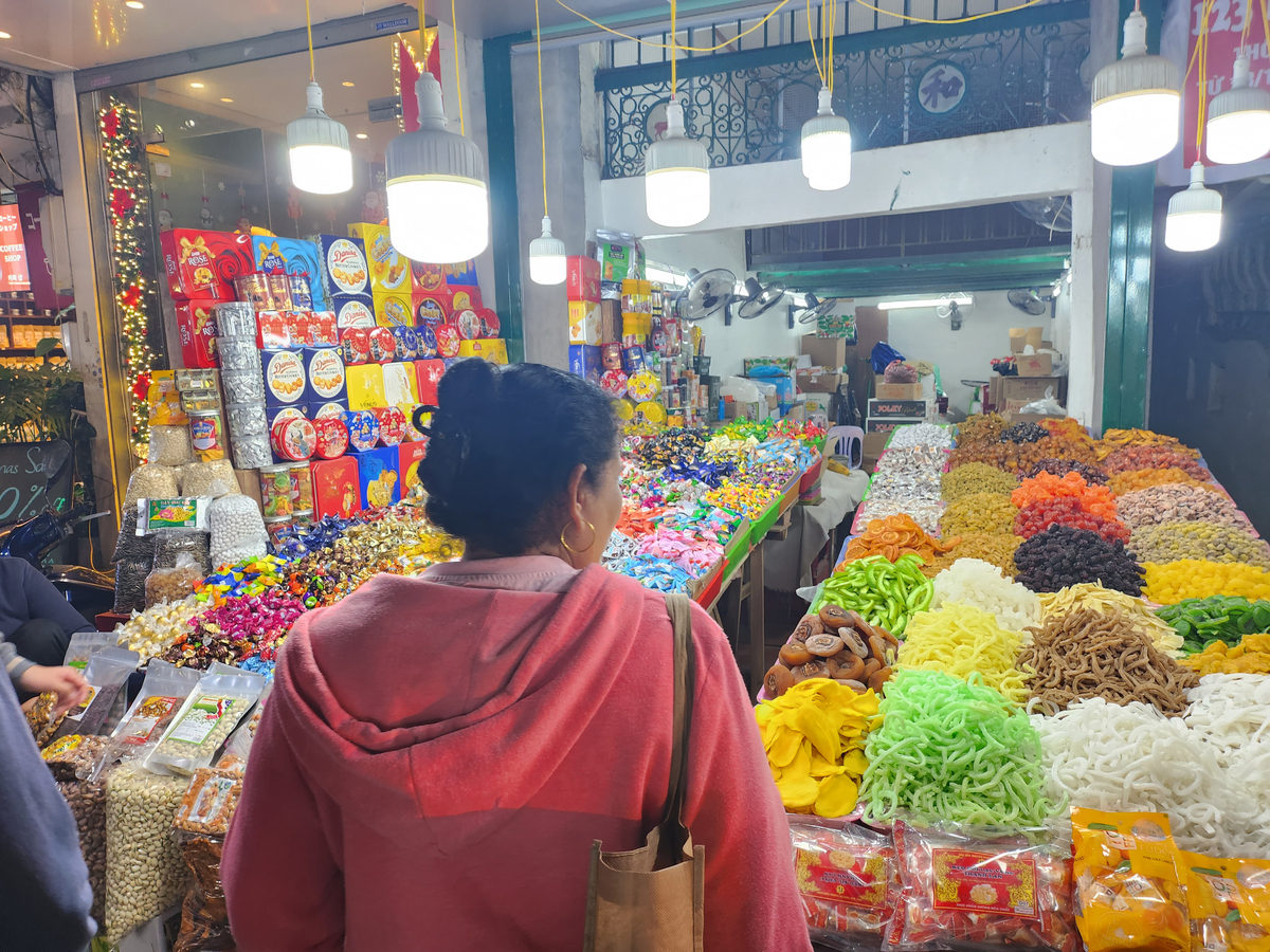 Một khách hàng đến mua bánh kẹo, mứt tại cửa hàng trên phố Hàng Buồm, Hoàn Kiếm, Hà Nội. Ảnh Trịnh Anh