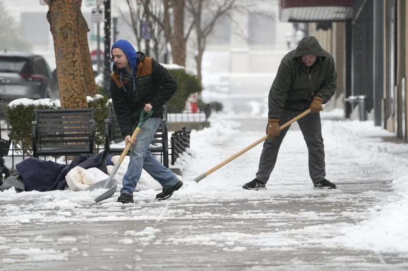 Jesse Asher (bên trái) và Eric Magas xúc tuyết vào ngày 18/1 ở Nashville, Tenn. (Ảnh: AP)