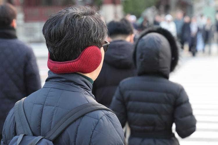 Người đi bộ ở trung tâm thành phố Seoul mặc quần áo dày để giữ ấm. (Ảnh: Yonhap)    