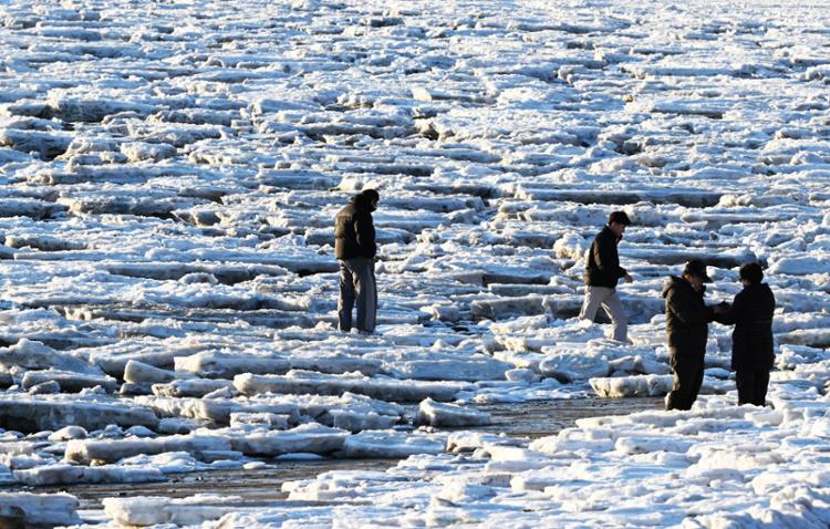 Du khách đi bộ trên lớp băng bao phủ bãi biển Dongmak trên đảo Gwanghwa, thành phố Seoul, phía Đông Seoul. (Ảnh: Yonhap)