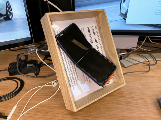 Để đảm bảo rằng mình sẽ không bao giờ thay đổi quyết định, Juhani đã đóng khung chiếc Galaxy Z Flip3 bị hỏng kèm theo giấy từ chối bảo hành và đặt trên bàn làm việc | Ảnh: Juhani