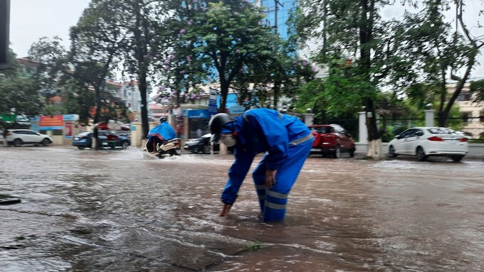 Nhân viên đô thị có mặt tại điểm ngập úng để khơi thông dòng chảy.