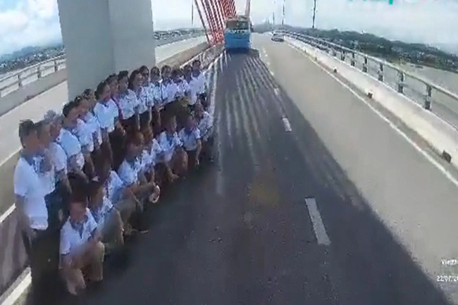 Nhóm 20 người dàn hàng chụp ảnh trên cầu Cửa Hội gây mất an toàn giao thông (ảnh cắt từ clip)