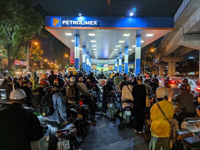 Đêm trước ngày điều hành tại Hà Nội, nhiều cây xăng đông bất thường khi người dân ùn ùn xếp hàng chờ đổ xăng. Ảnh Thanhnien