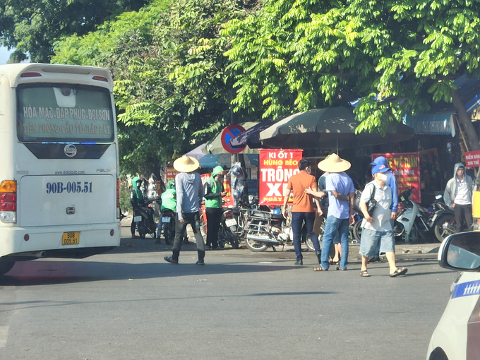 Cảnh 'cò xe', nhân viên nhà xe thường xuyên tụ tập trước cổng Bến xe Giáp Bát chèo kéo, bắt khách